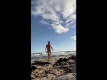 Hombre desnudo caliente nada en una playa pública.